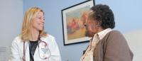 Female physician smiling with elderly patient.